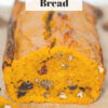 loaf of pumpkin bread with text overlay "Pumpkin Cranberry Bread".
