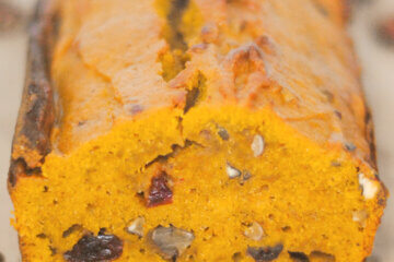 loaf of pumpkin bread with text overlay "Pumpkin Cranberry Bread".