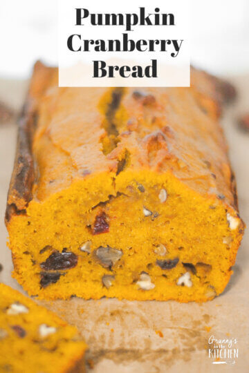 loaf of pumpkin bread with text overlay "Pumpkin Cranberry Bread".