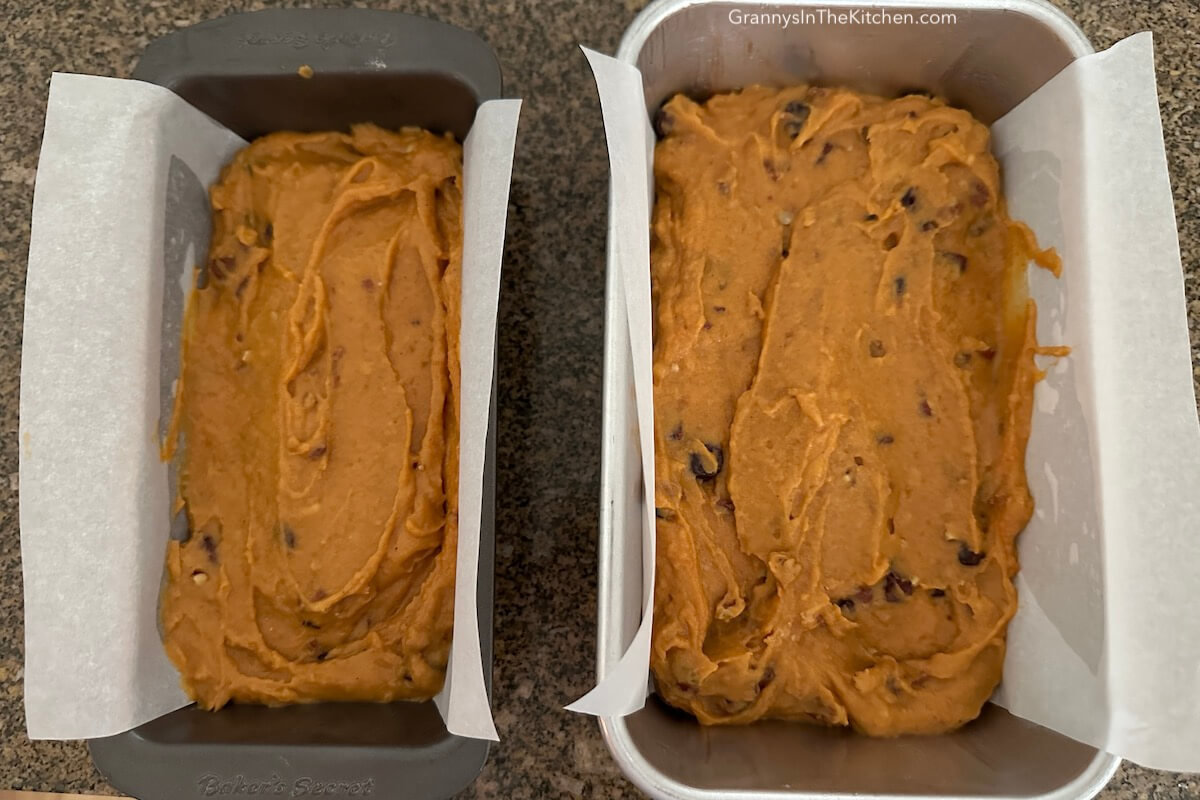 2 batches of pumpkin cranberry bread batter in loaf pans.