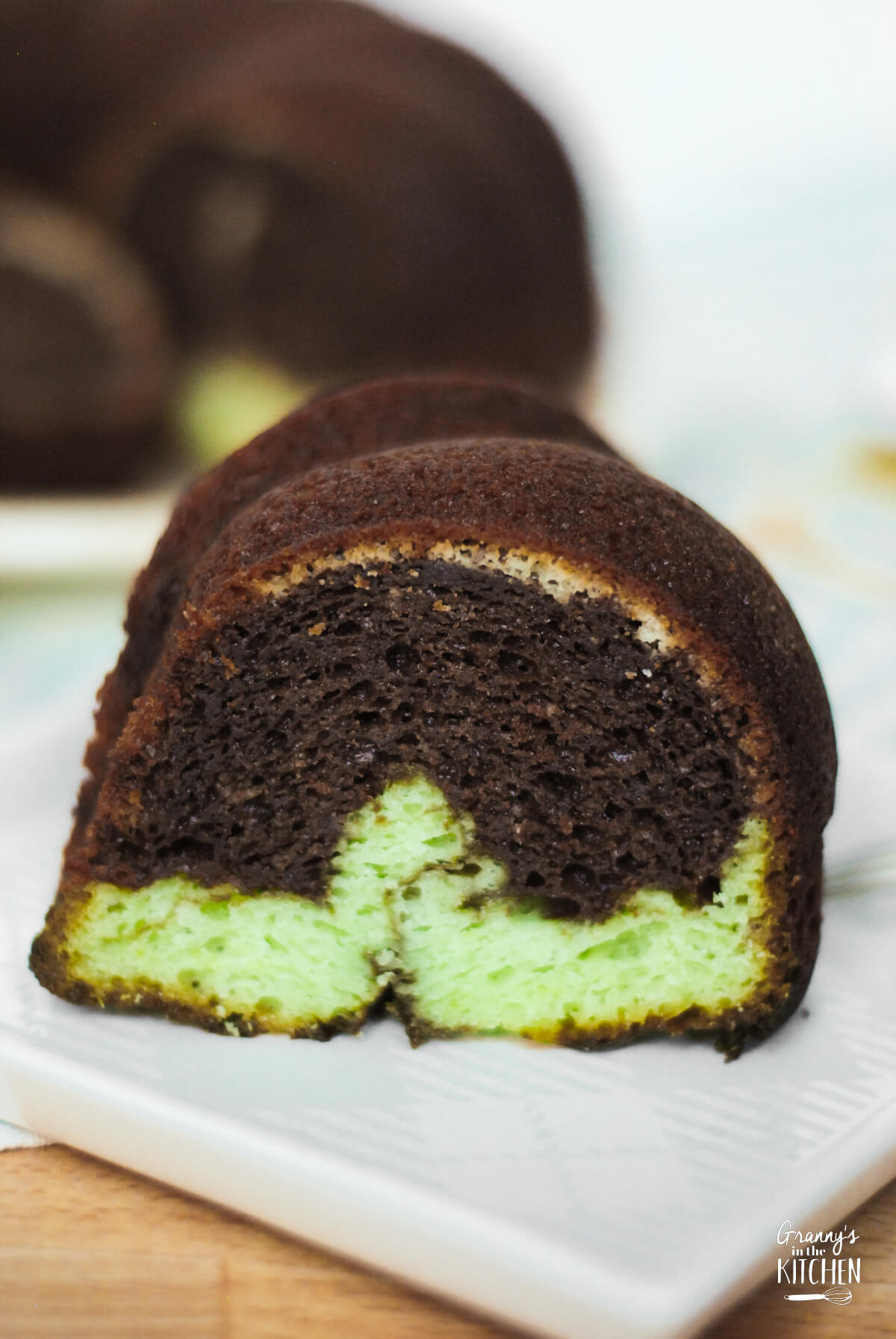 close up of a slice of green and brown swirled chocolate pistachio bundt cake.