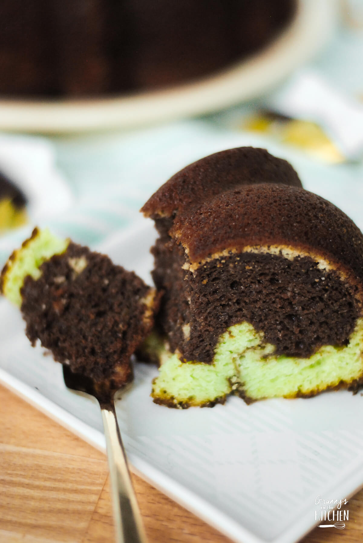 a slice of pistachio and chocolate swirled bundt cake, with a bite taken.