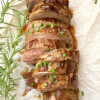top down view of a sliced pork loin, text overlay "Marinated Pork Tenderloin".