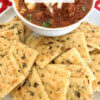 seasoned crackers next to a bowl of chili.