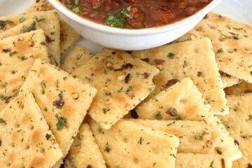seasoned crackers next to a bowl of chili.