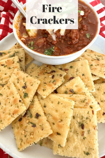 seasoned crackers next to a bowl of chili.