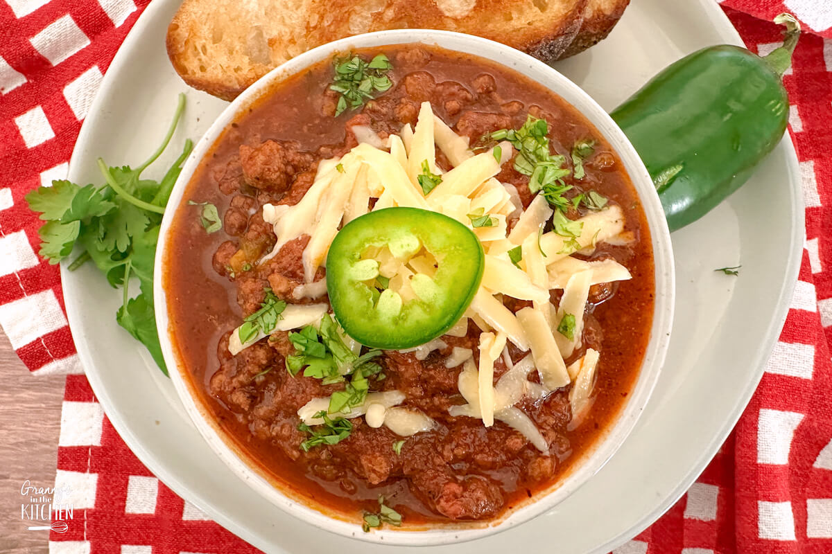 bowl of chili topped with cheese and jalapenos.