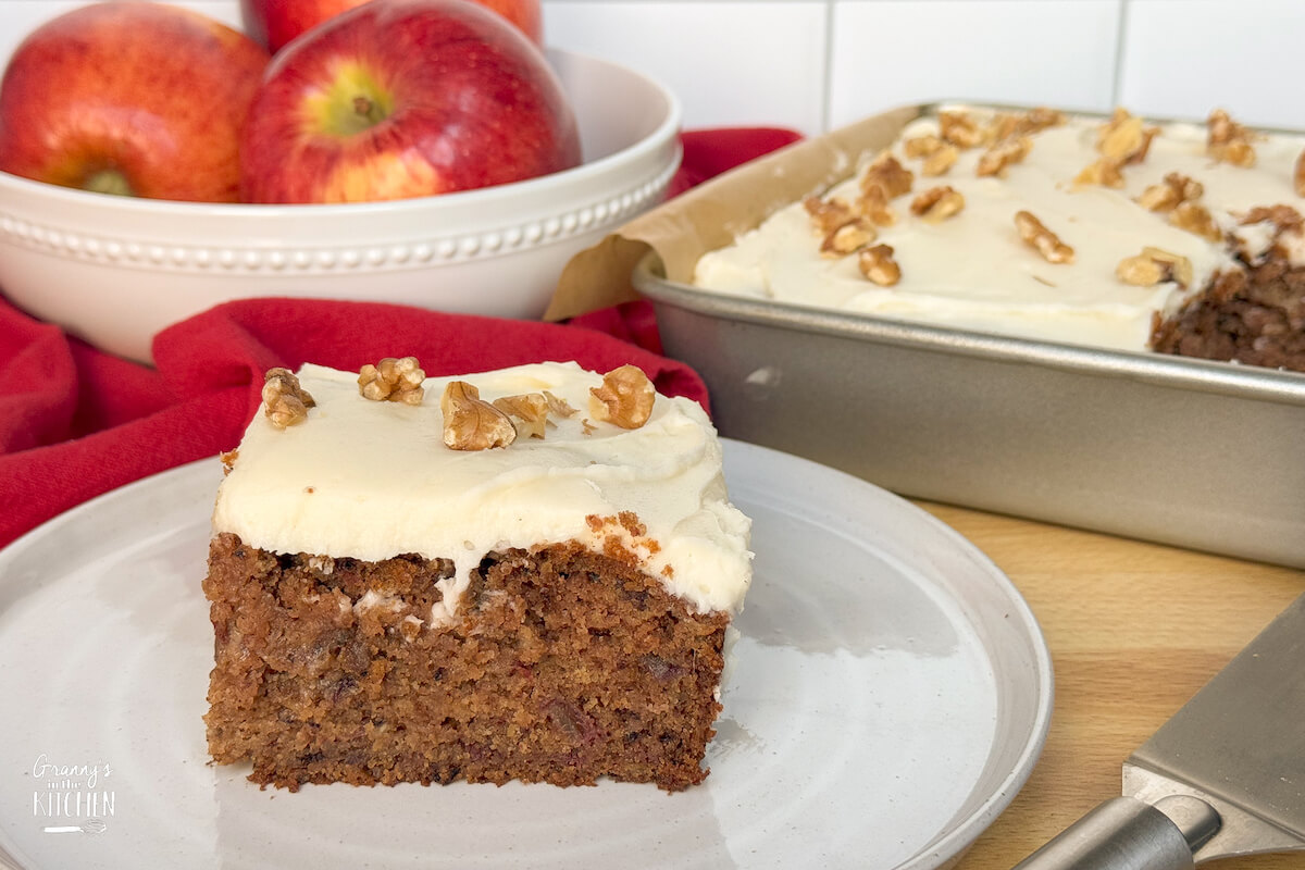 slice of cake on plate with full cake in background.