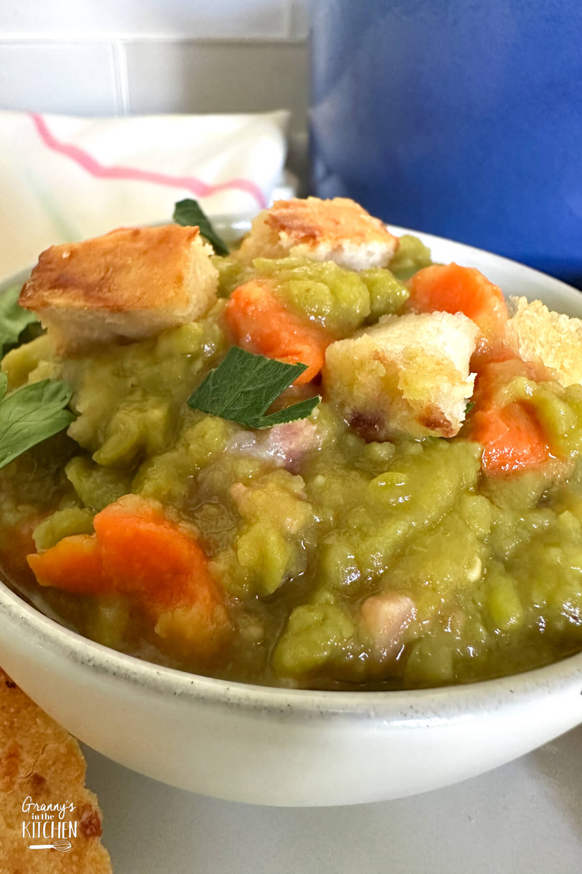 close up on a bowl of split pea soup topped with homemade croutons.