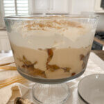 Trifle dish layered with cake, butterscotch pudding, and whipped cream.