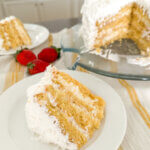 coconut layer cake, 2 slices and whole cake in background.
