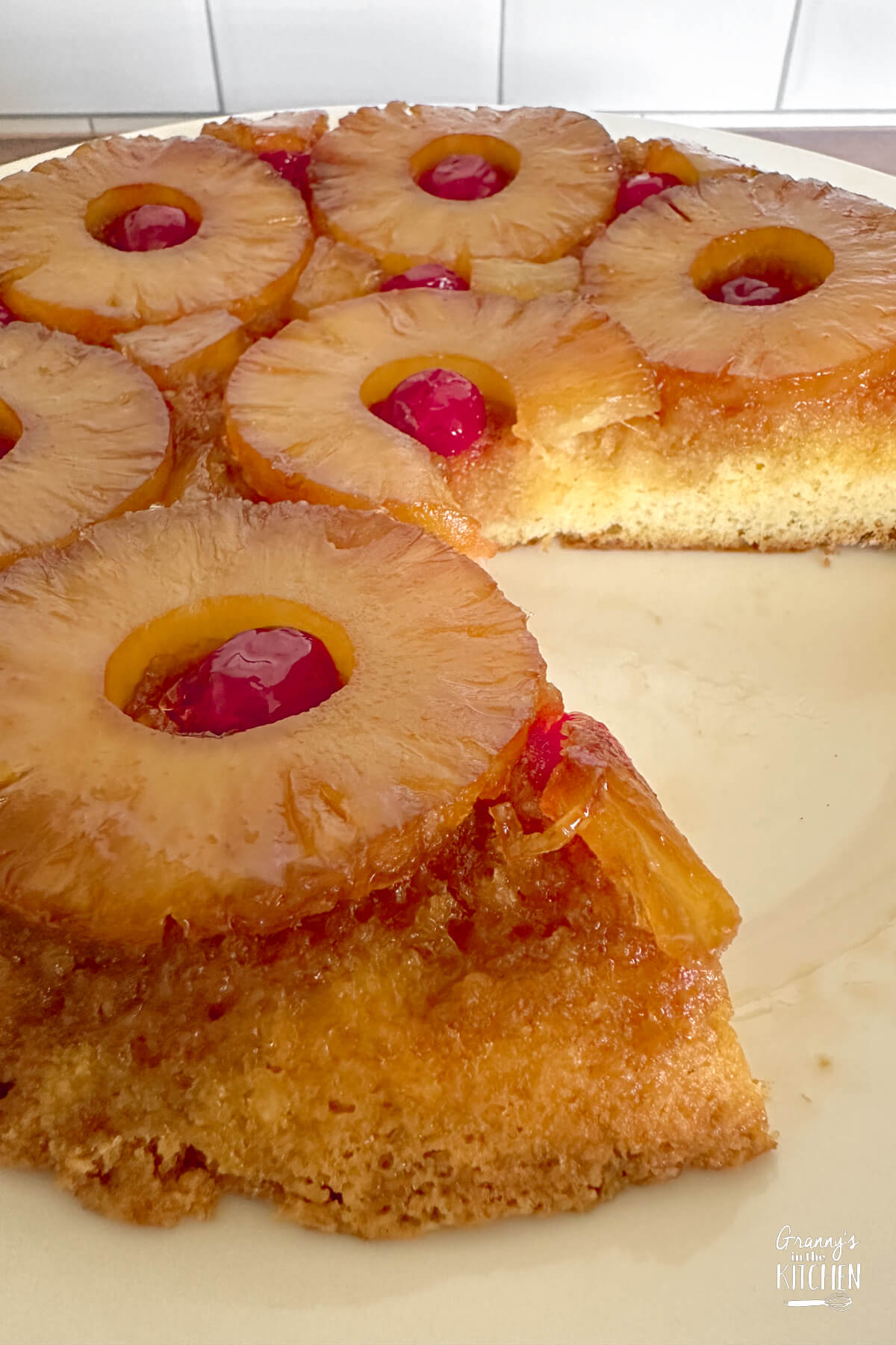 skillet pineapple upside down cake, with a slice missing.