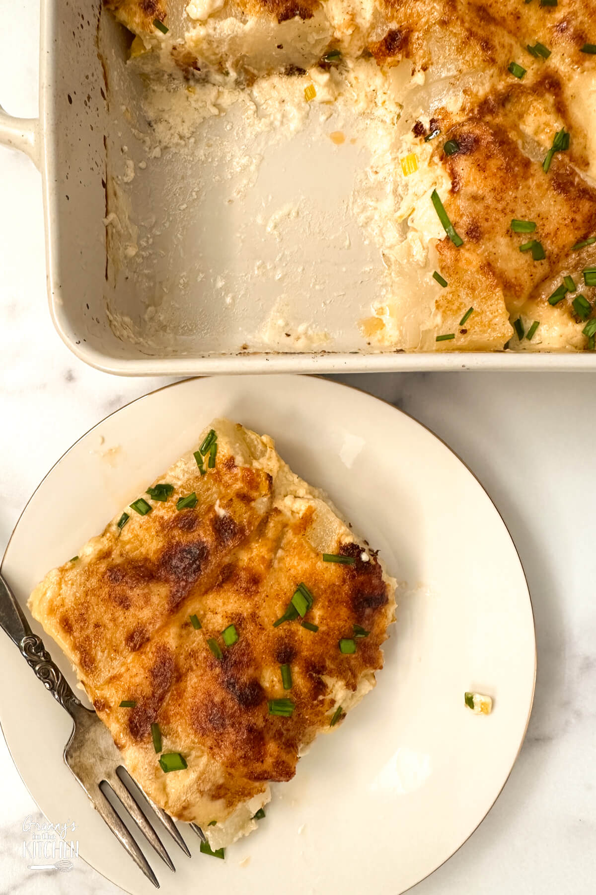 individual serving of turnip gratin, with casserole dish in background.