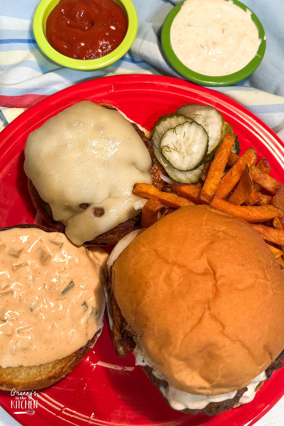 top down view of 2 burgers on a plate, one open face.