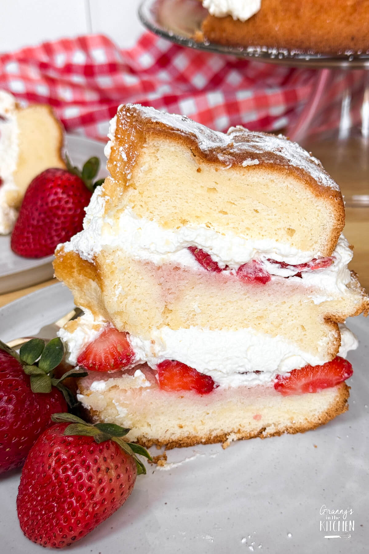 slice of strawberry chiffon cake standing up on a plate.