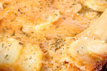 pan of scalloped potatoes with text overlay of recipe name.