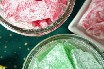 two mason jars of red and green candy, with text overlay "Hard Tack Candy"