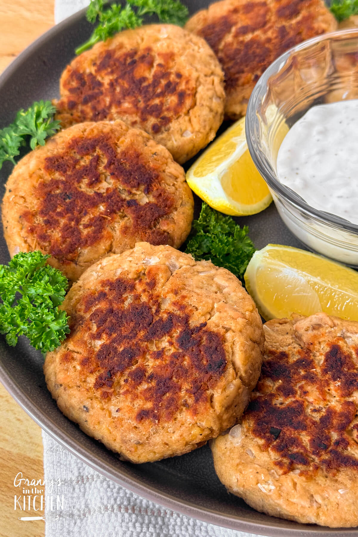 close up of pan fried salmon patties on a plate.