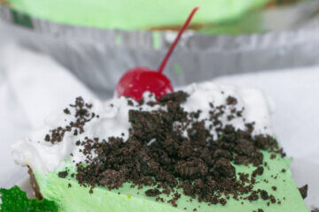 Slice of mint green pie with full pie in background; text overlay "Grasshopper Pie."