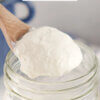 Homemade Sour Cream being spooned out of a jar.