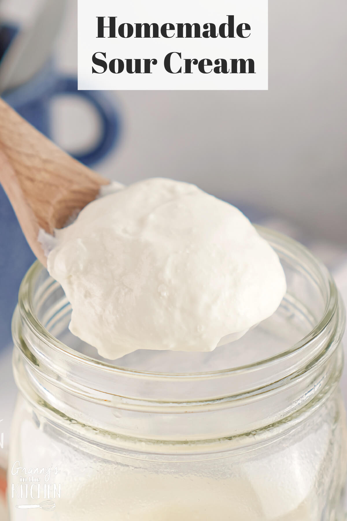Homemade Sour Cream being spooned out of a jar; text overlay "Homemade Sour Cream."