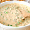 a bowl of peas in a thick and creamy cheese sauce; text overlay "Cheesy Peas."