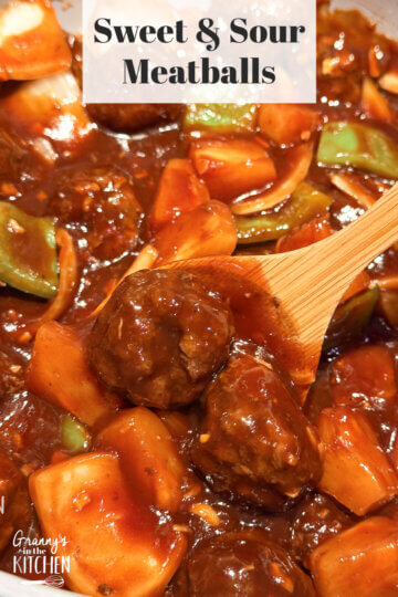 A wooden spoon dipping into sweet and sour meatballs with a text overlay "Sweet and Sour Meatballs."