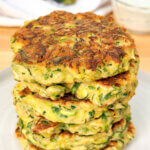 stack of fried zucchini patties with text overlay "Zucchini Fritters"