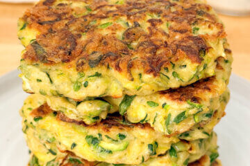 stack of fried zucchini patties with text overlay "Zucchini Fritters"