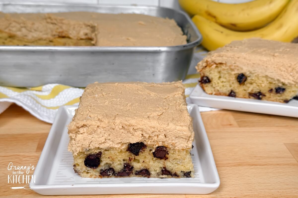 a slice of chocolate chip banana cake with the pan in background.
