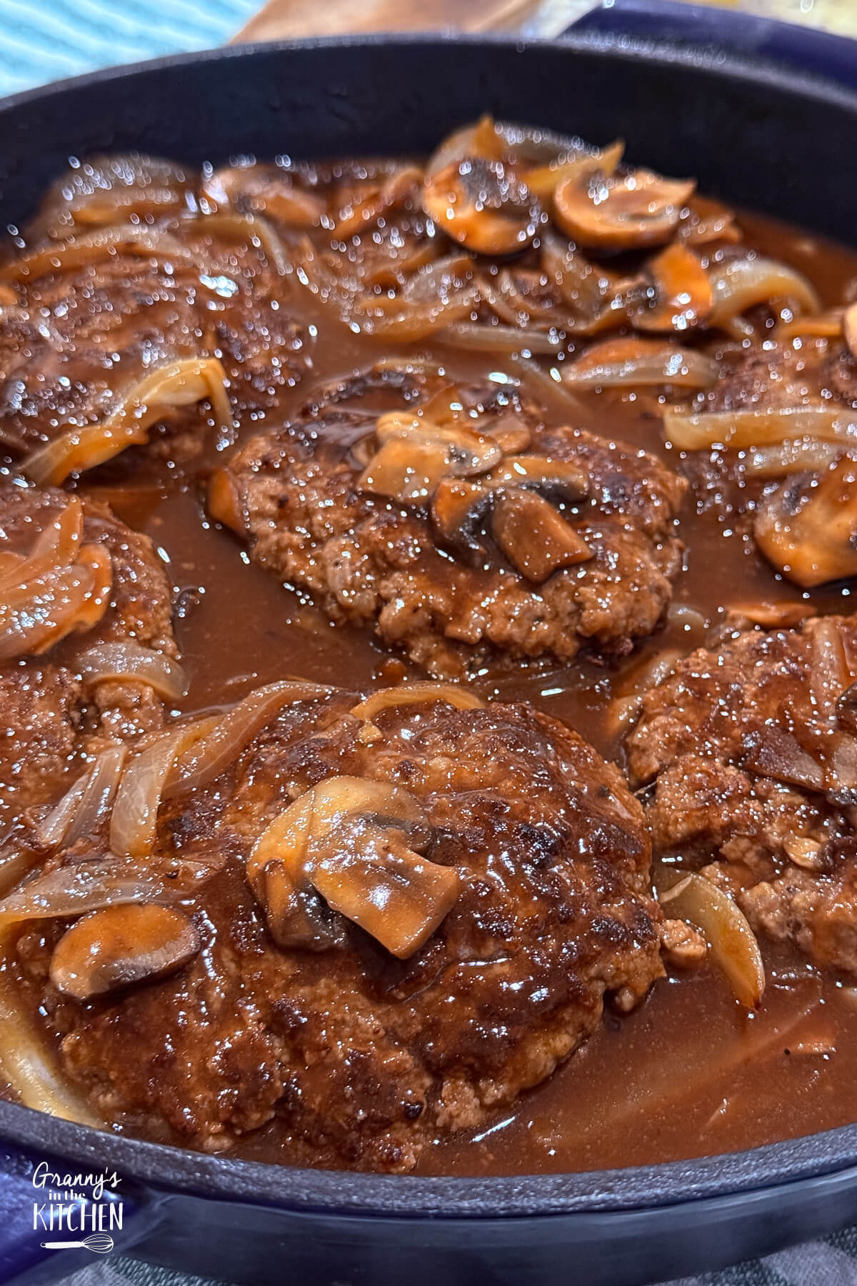 close up of Salisbury steak cooking in skillet.