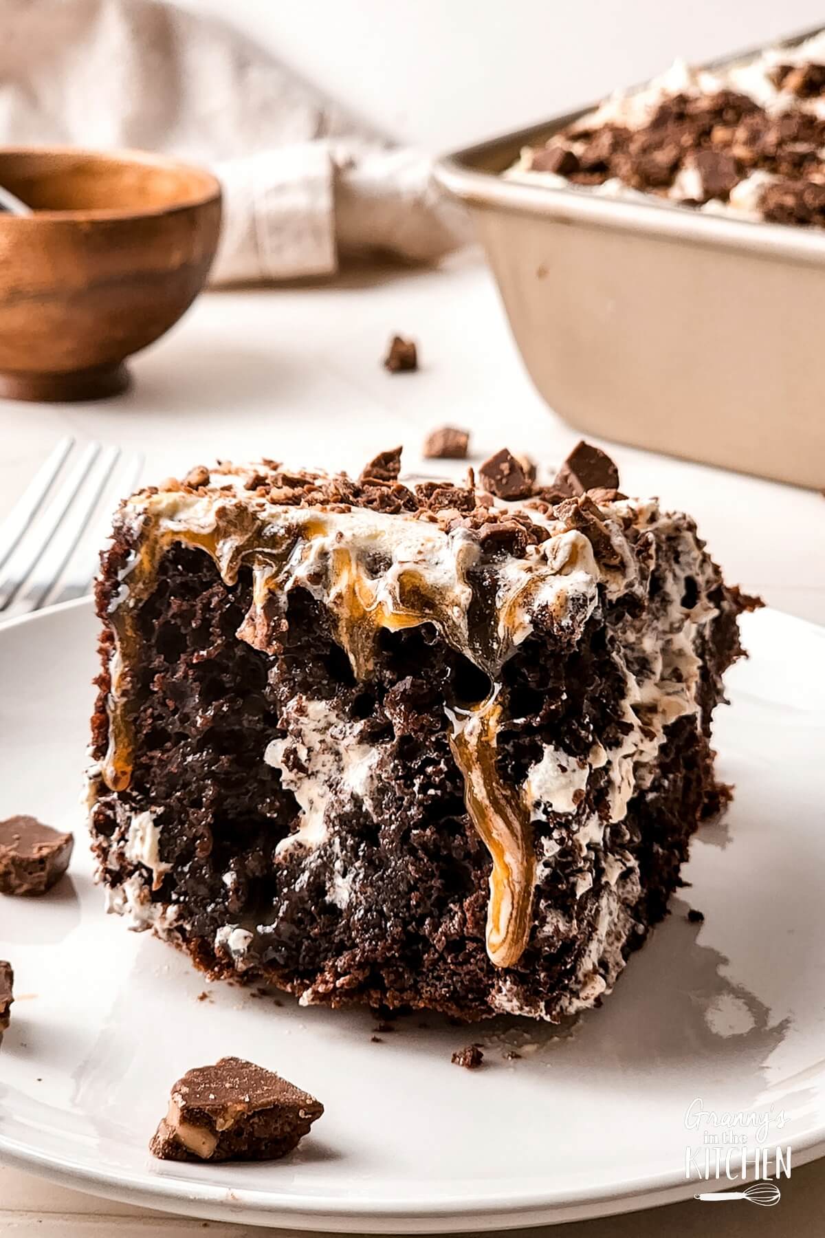 A slice of Toffee Poke Cake on a white plate.