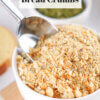 A bowl of Homemade Italian Bread Crumbs with a metal scoop in it.