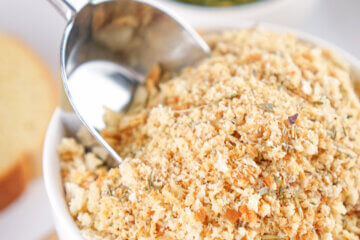 A bowl of Homemade Italian Bread Crumbs with a metal scoop in it.