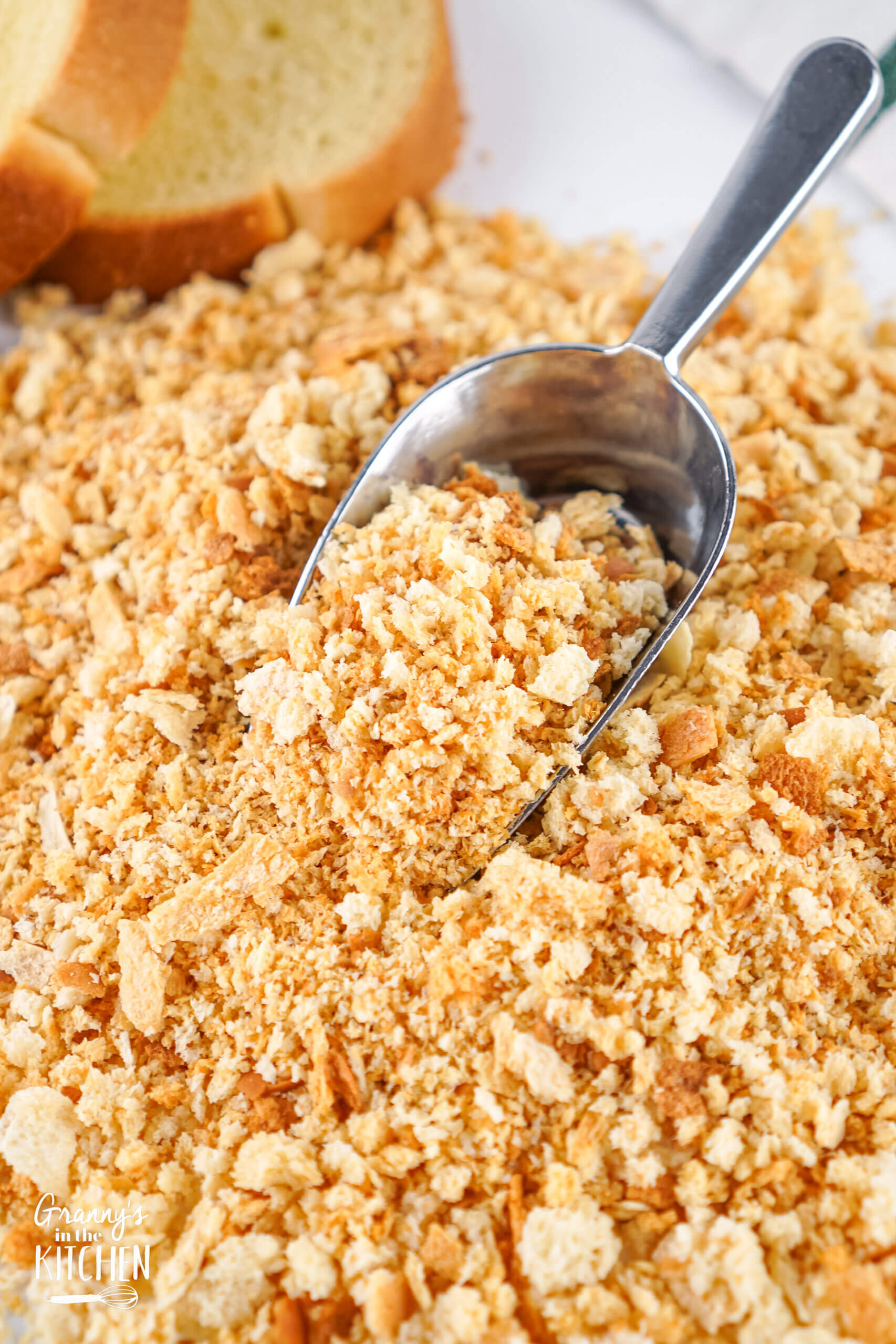 Homemade Italian Bread Crumbs with a metal scoop in it.